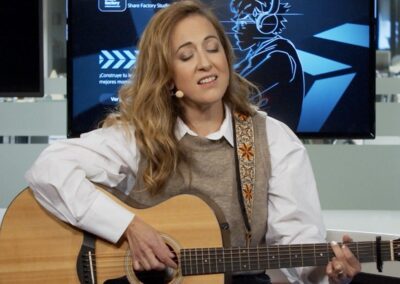 Mujer con ojos cerrados y tocando la guitarra mientras canta